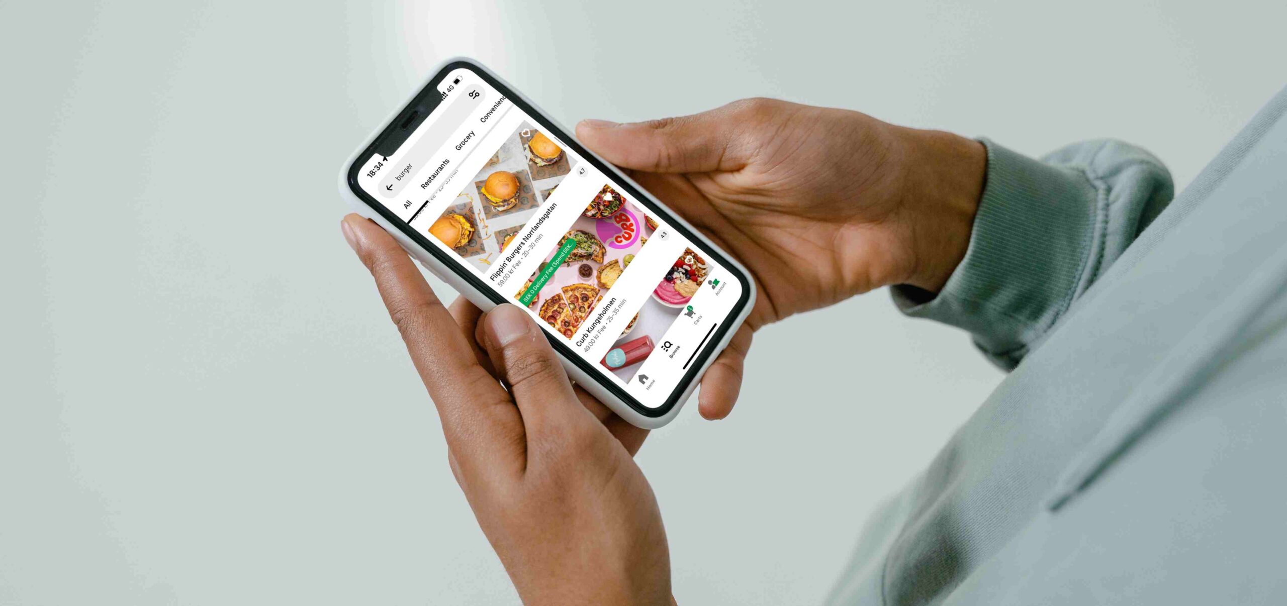 A person holding a smartphone displaying UberEats online restaurants